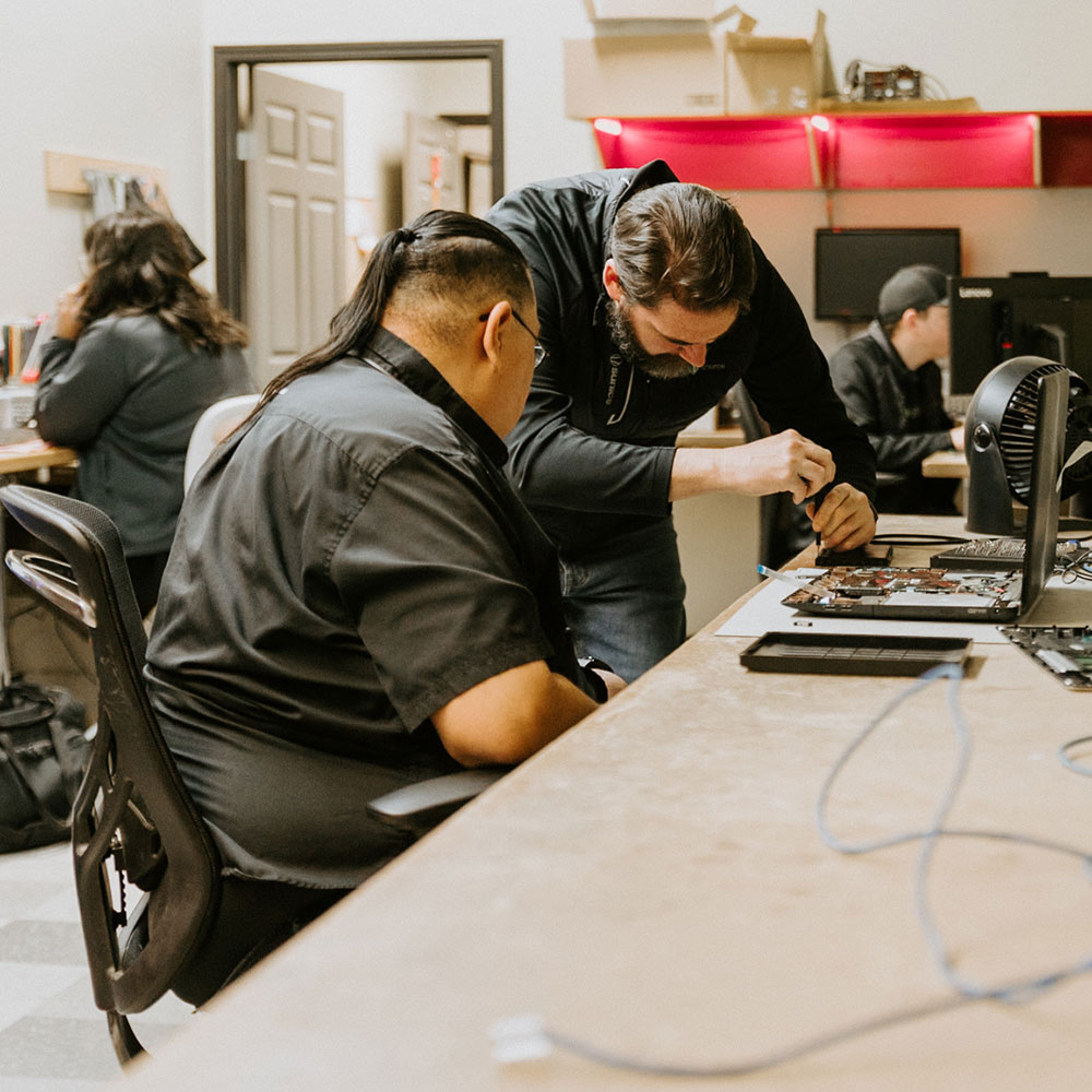 Technicians work on in-store repairs at myITsource in Brandon, Manitoba